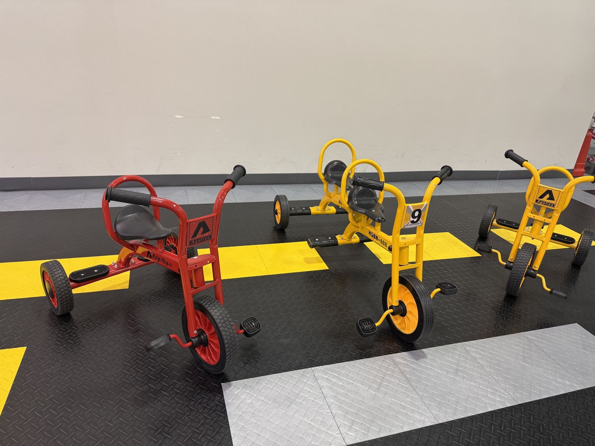 Ride-on tricycles lined up on the kids' race track at Play Grounds of La Crosse.