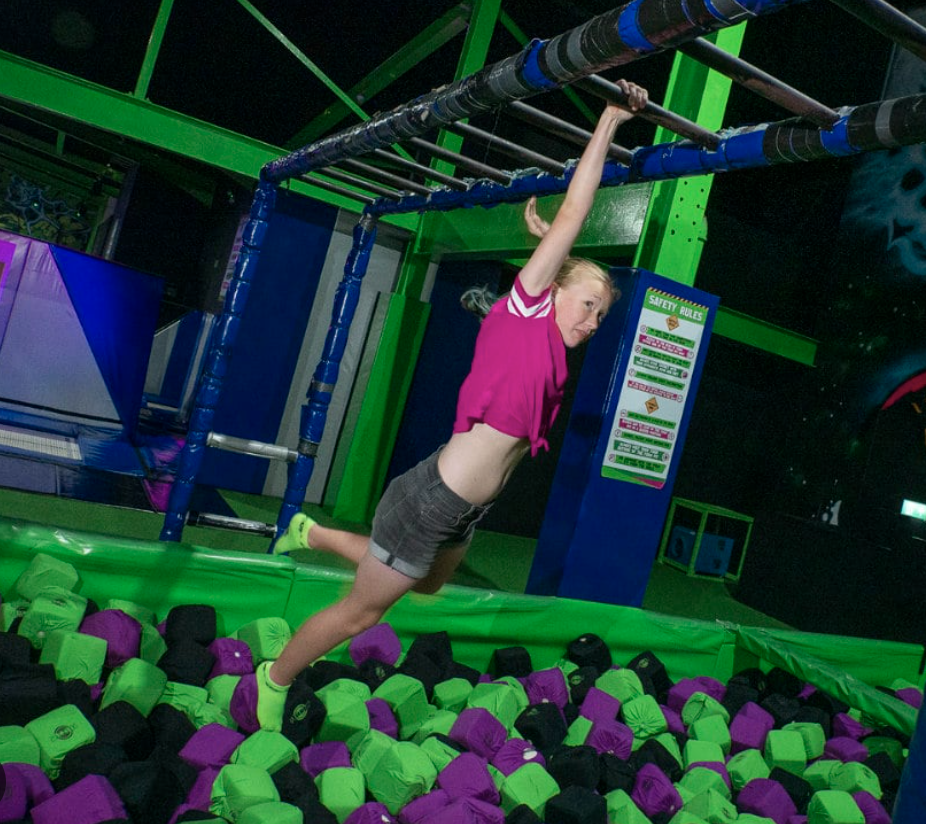 Child swinging over a foam pit obstacle at Play Lab