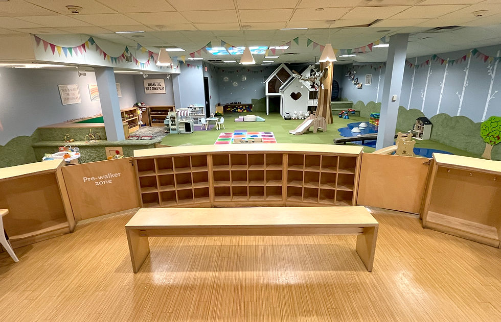 Entry view into The Playhouse with cubbies, seating, and a wide look across the play room.