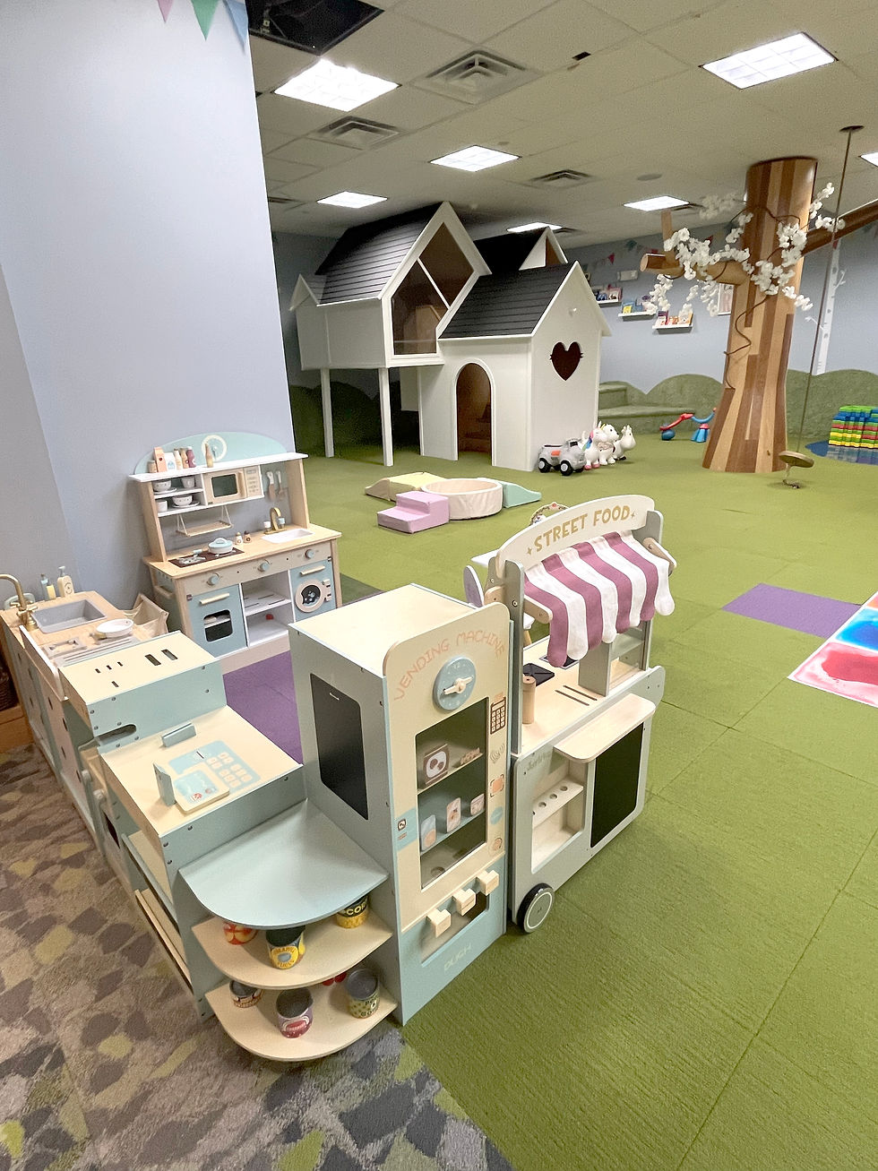 Pretend-play market and house setup inside The Playhouse.