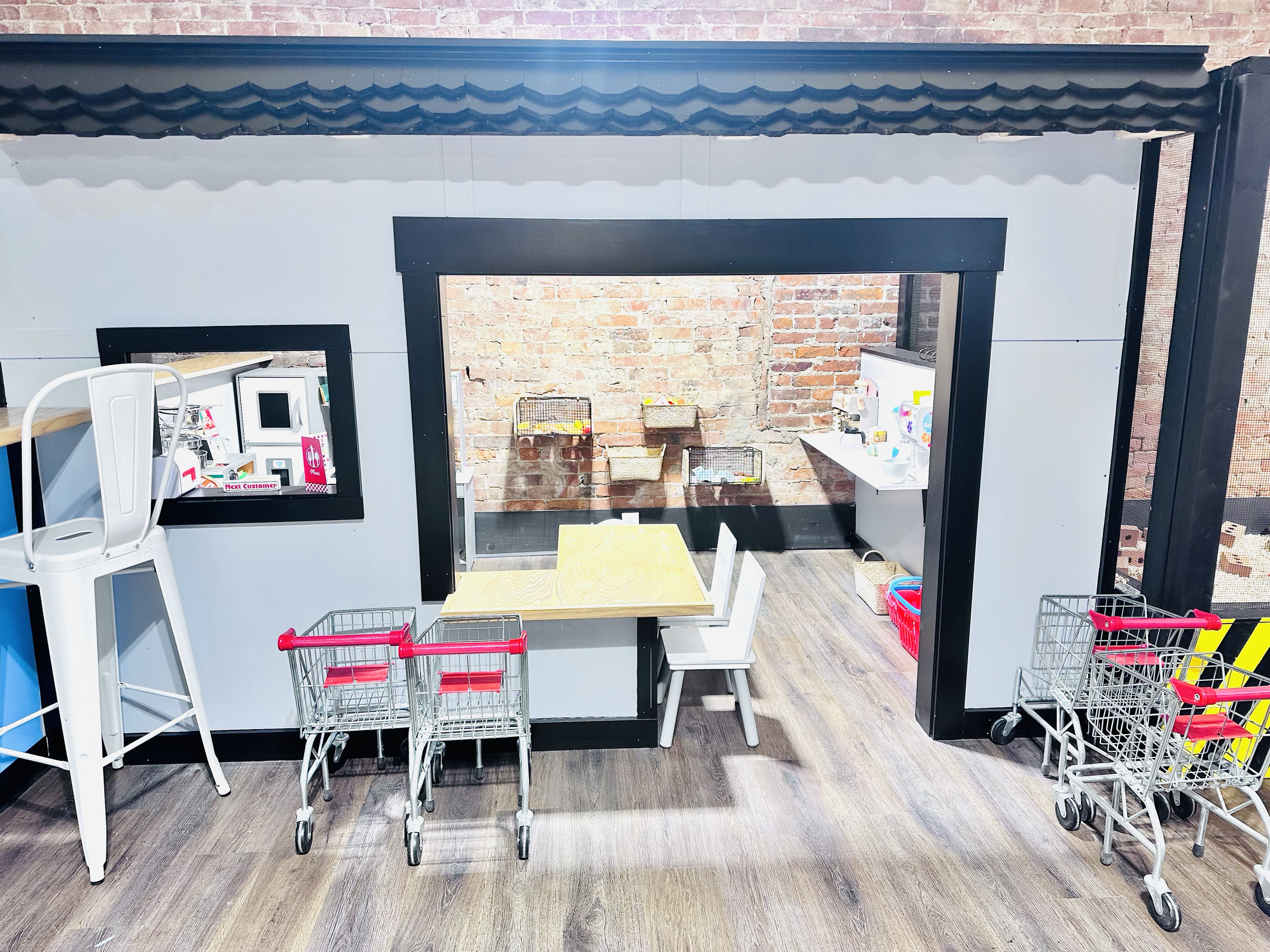 Pretend-play setup with playhouse and toys inside Playhouse Cafe