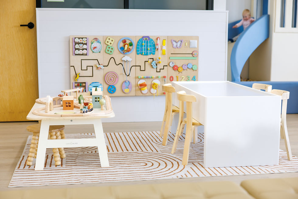 Toddler-focused activity table and small slide area at Playtown Cafe