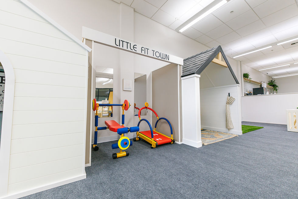 Pretend-play storefront and child-sized fitness toys at Playtown Cafe