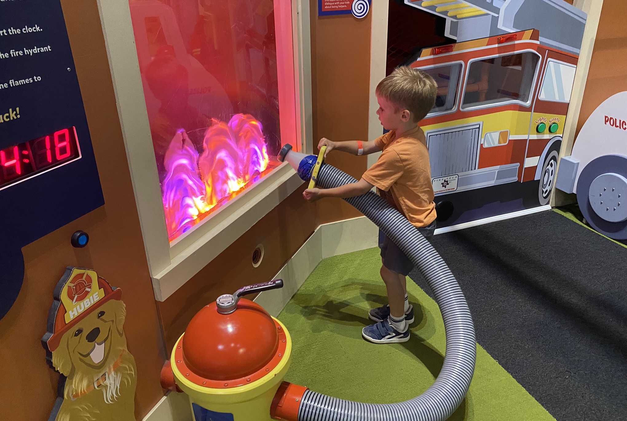 Child using the firehouse-style interactive exhibit at PoP Children’s Museum.