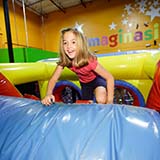 Child climbing on Pump It Up inflatable equipment