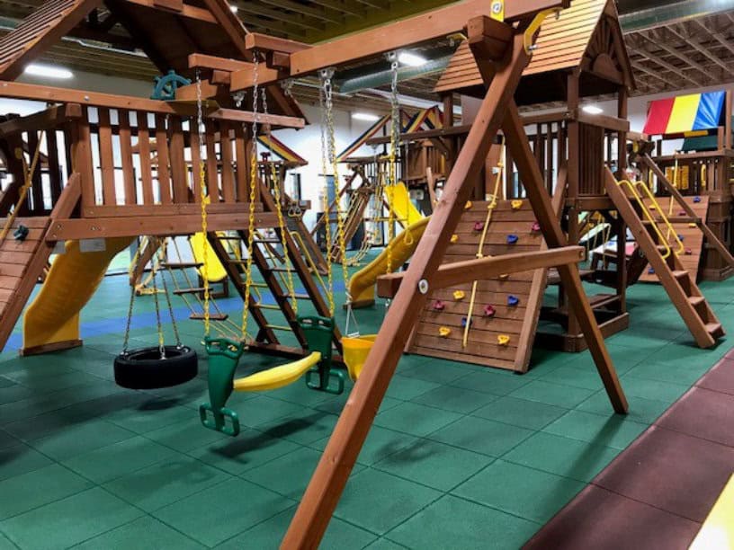 Children playing on trampolines and climbing equipment inside Rainbow of the Heartland Des Moines.