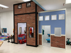 Pretend-play firehouse and medical center inside Rainforest Play Zone.