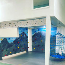 Climbing wall and net swing area inside Rainforest Play Zone.