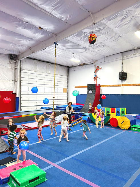 Children playing across the open gym floor at Roots Gymnastics & Dance.