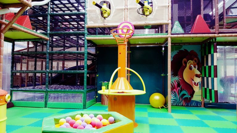 Large indoor play structure at Safari Nation Greensboro with jungle-themed active-play equipment.