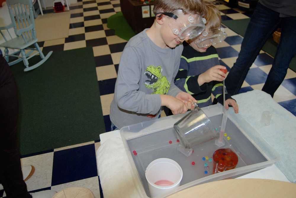 Children using a water and sensory activity table inside Sitka Children's Museum.
