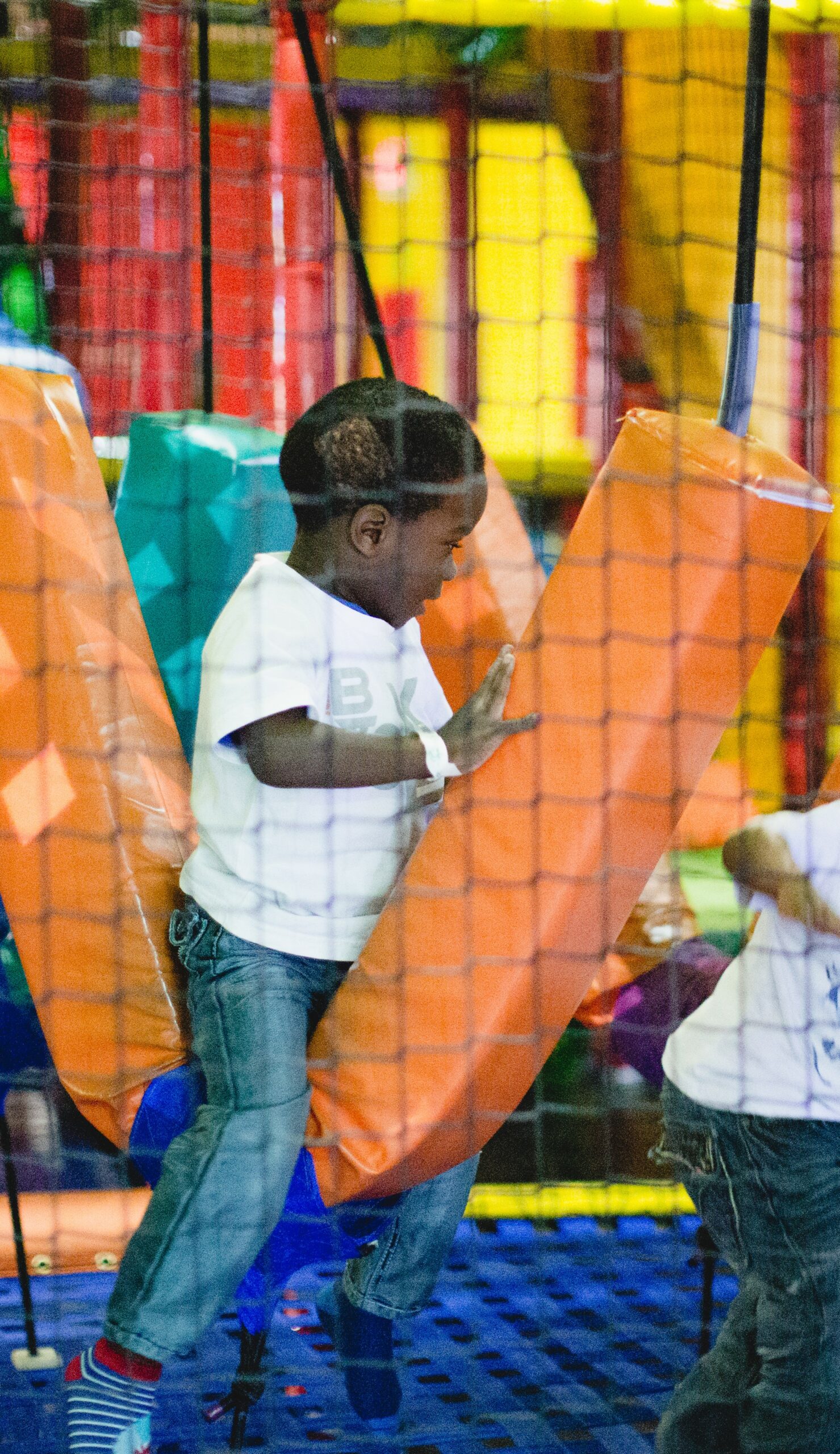 Child climbing through the indoor playground at Skate World Center