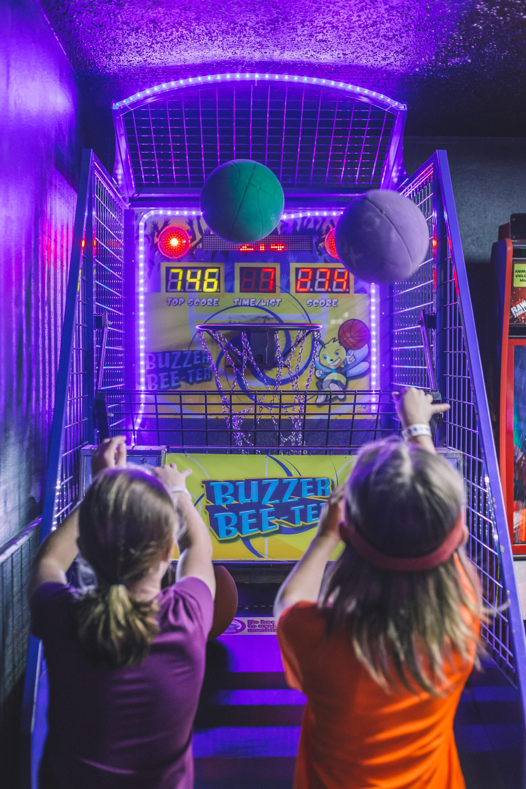 Kids playing a basketball arcade game at Skate World Center