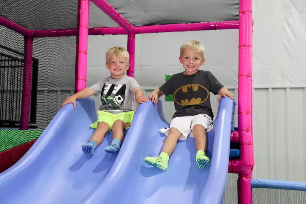 Younger-child activity area at Sky's The Limit with smaller slides and padded play features.