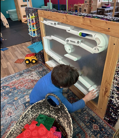 Child using a STEM-style wall activity at Space To Play