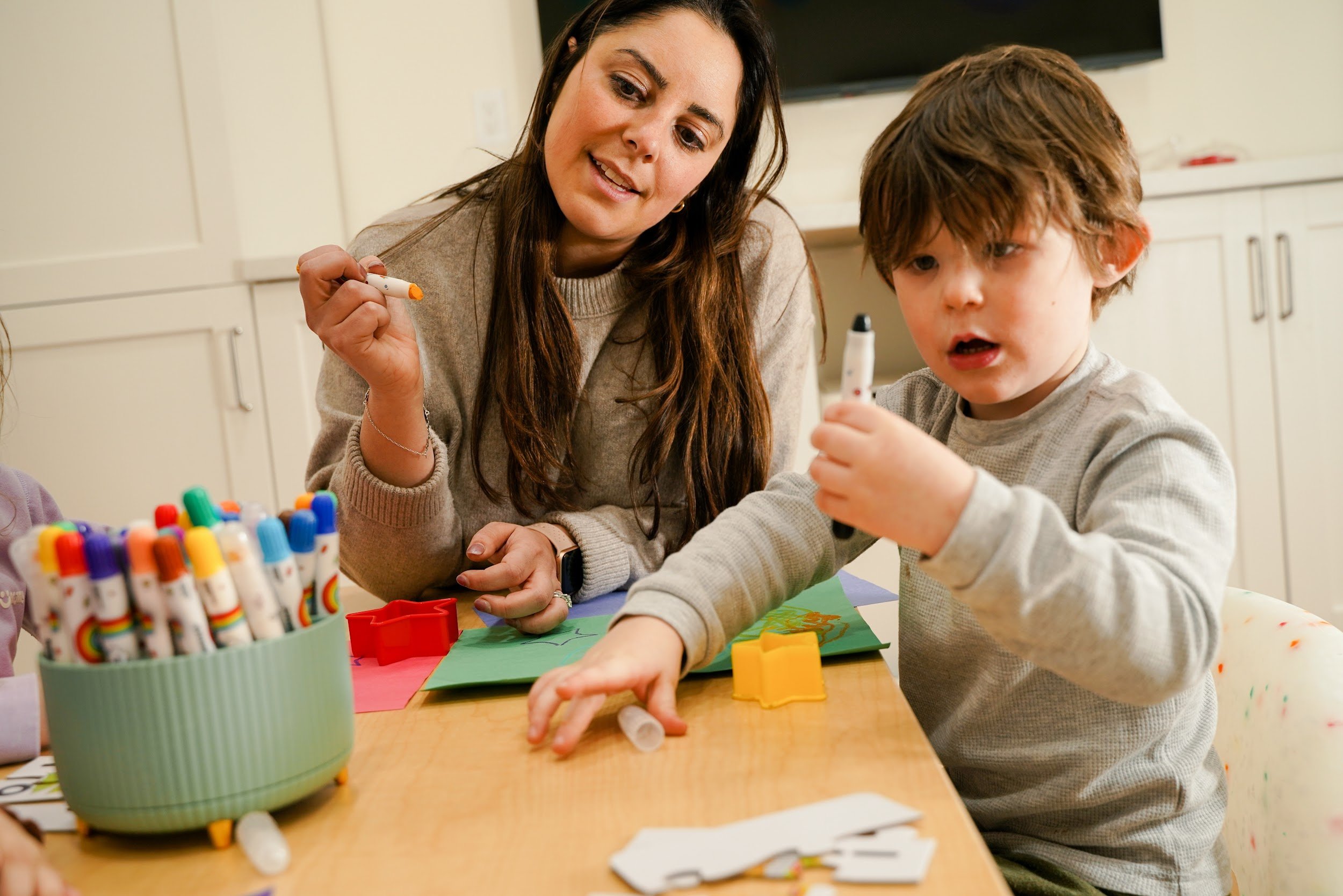 Caregiver and child working on a craft at Spark Place in Jersey City.