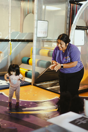 Young child with a staff member inside the SuperKidz Club playground