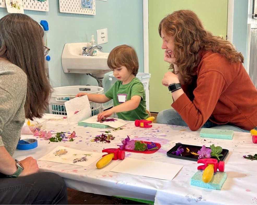 Adult and children doing a hands-on art activity at The Children's Playhouse.