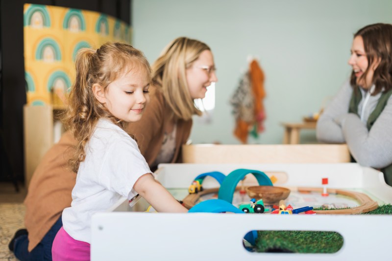 Caregiver and child playing together at The Emerging Parent in Holt.
