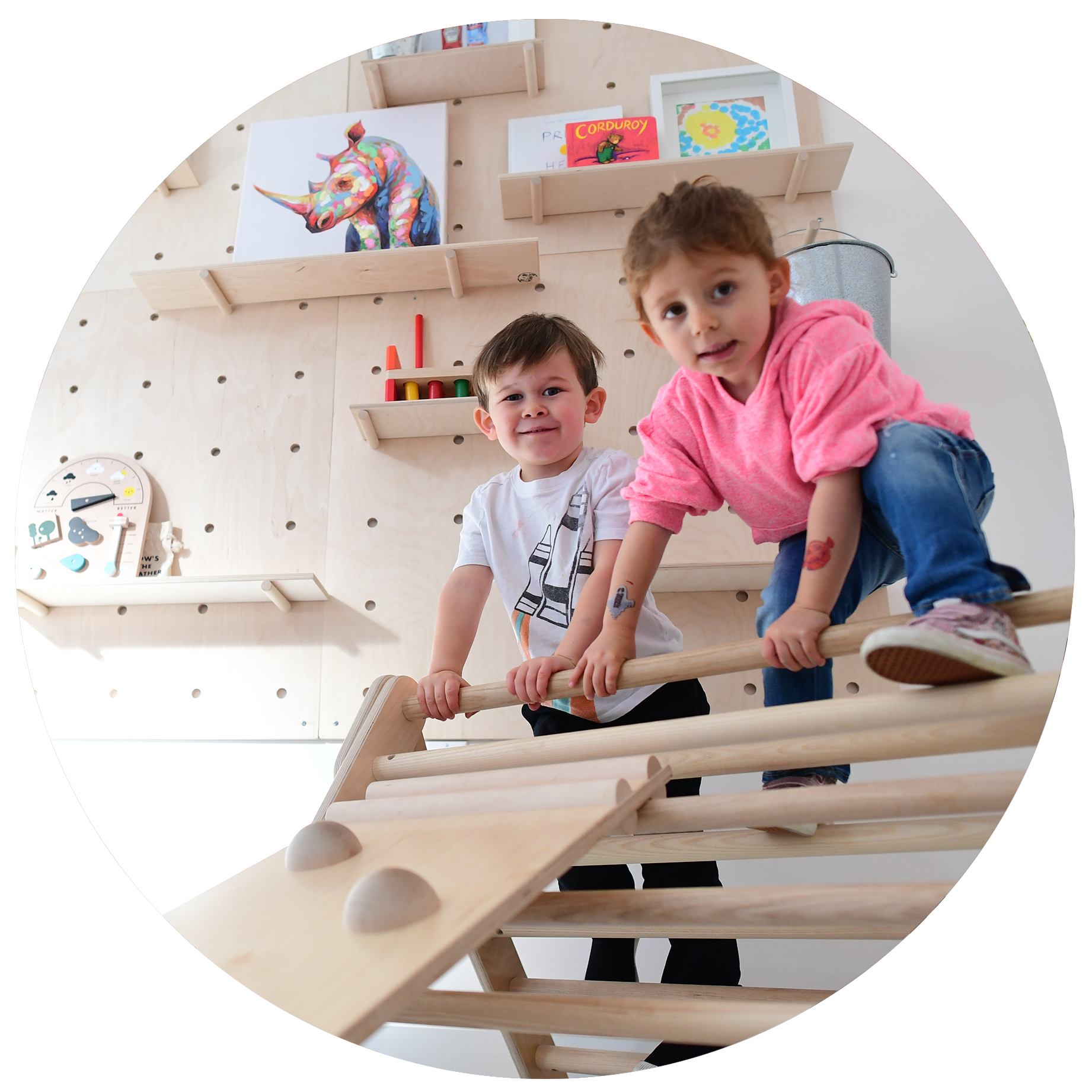 Children climbing on a wooden indoor play structure at The Hive.