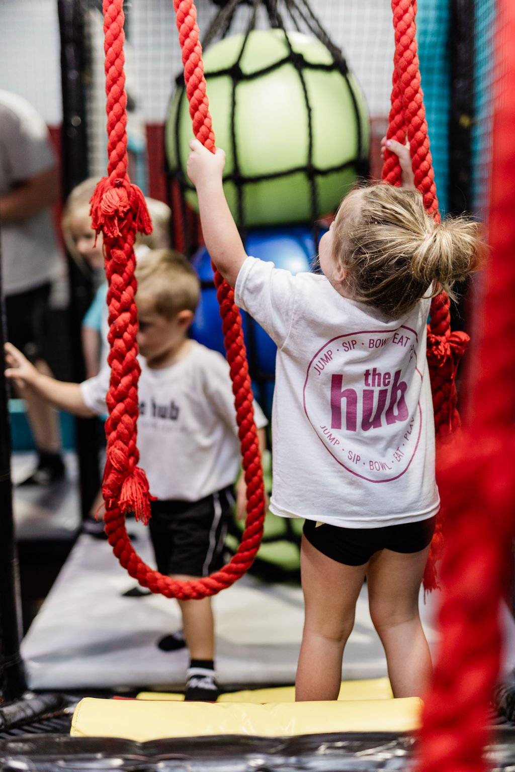 Children climbing rope elements inside The Hub in Council Bluffs