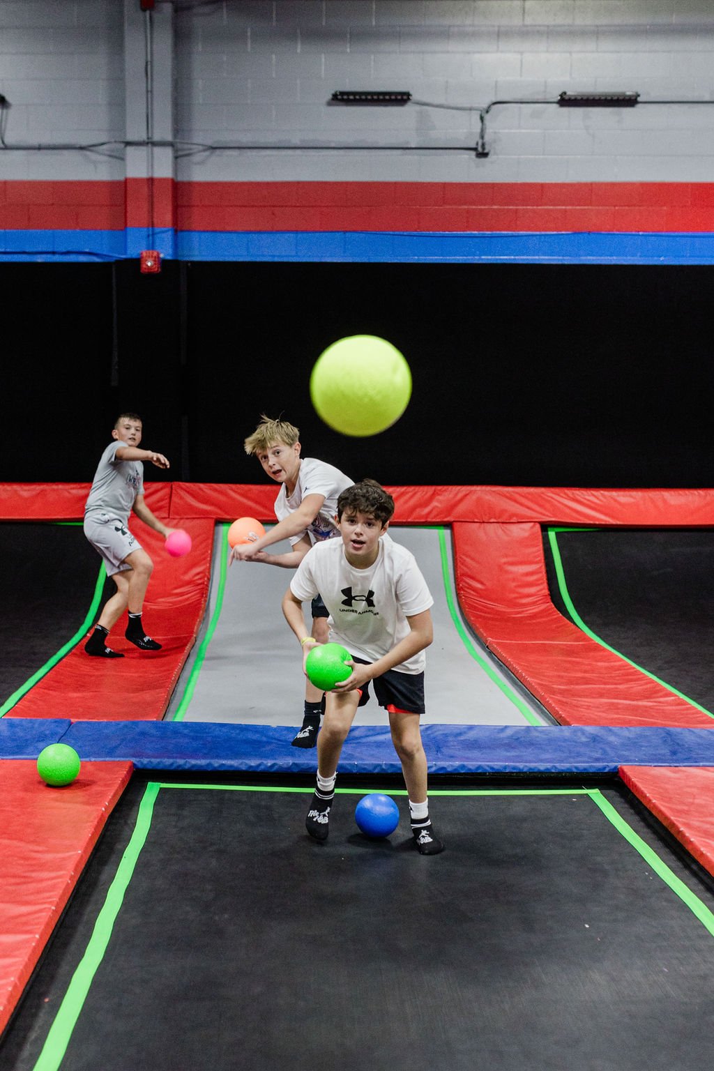 Older kids playing dodgeball on trampoline courts at The Hub