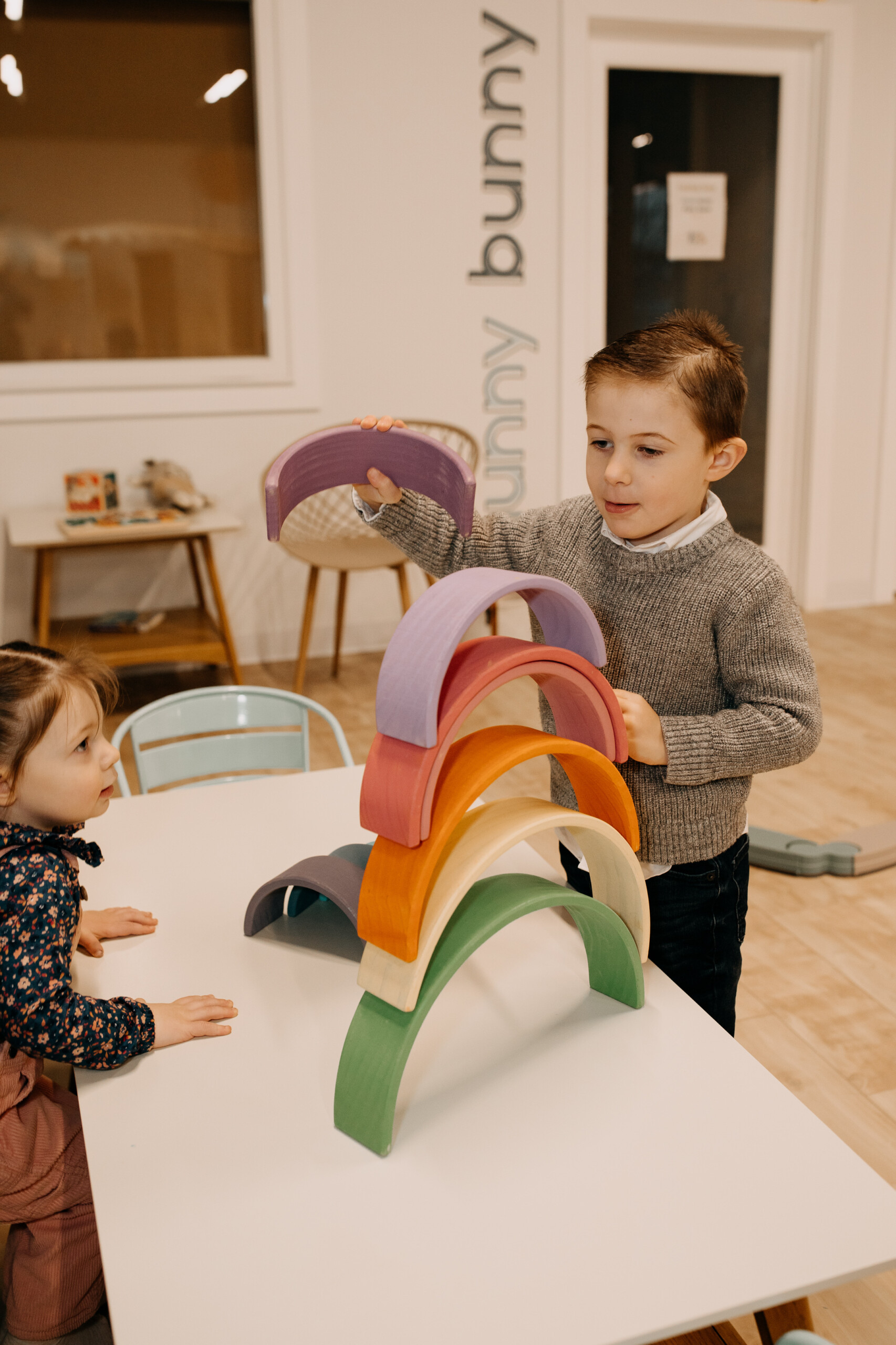 Children using open-ended toys at a play table inside The Little Things Play Cafe.