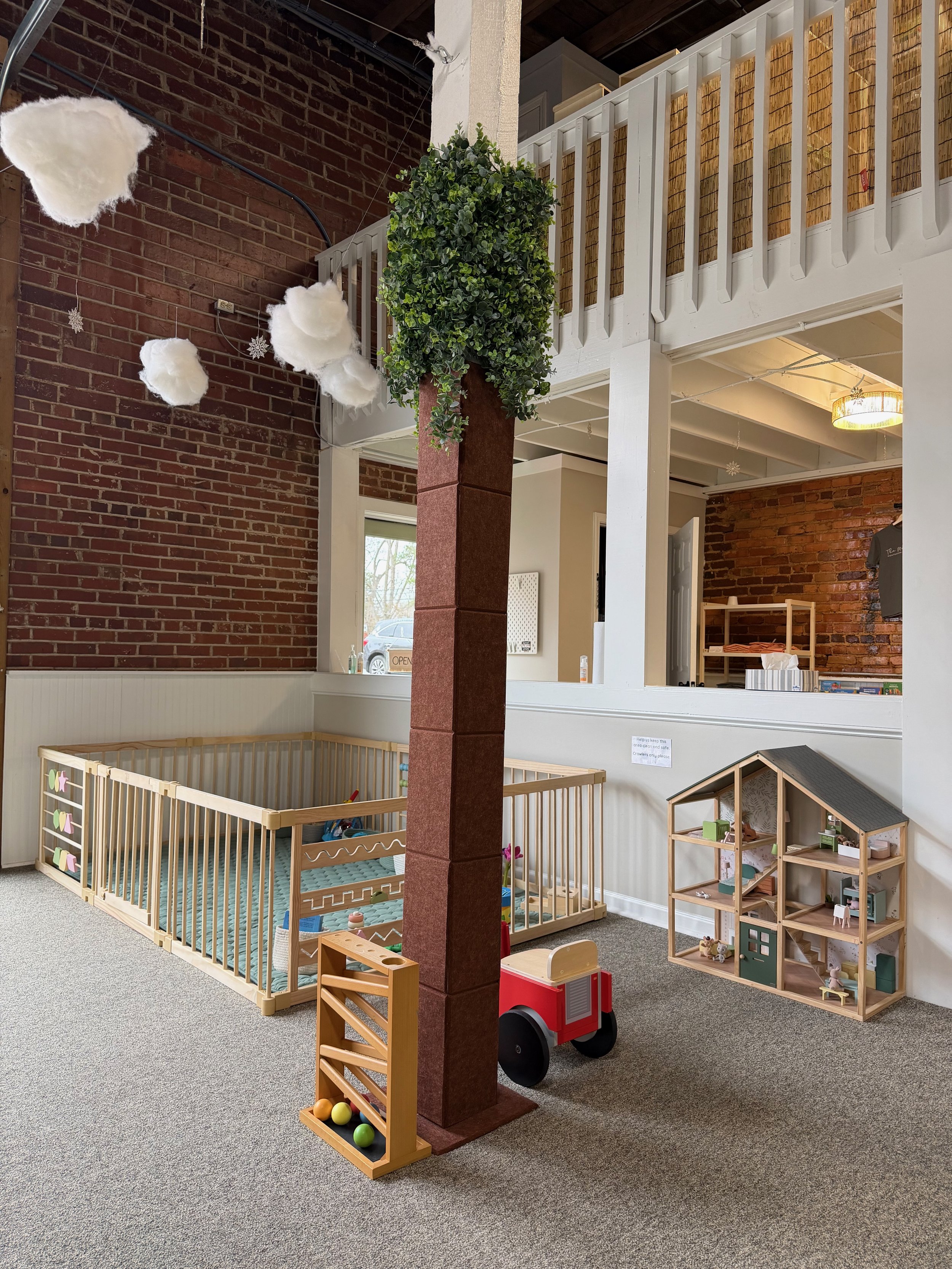 Toddler-friendly play area with fenced baby zone and dollhouse at The Meadow Montessori Play Studio