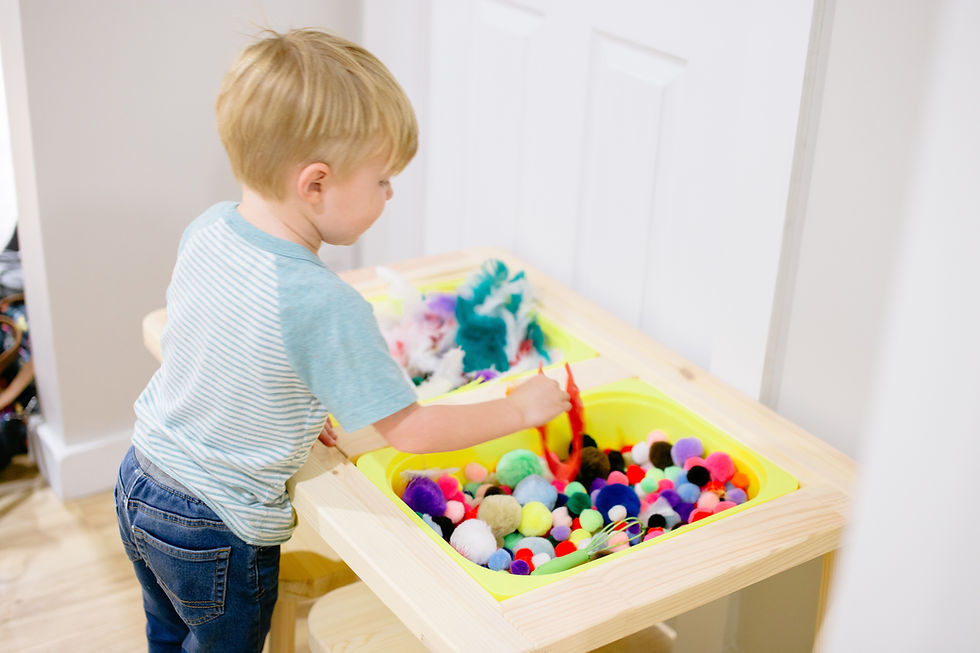 Child using a sensory bin at The Play Hut.