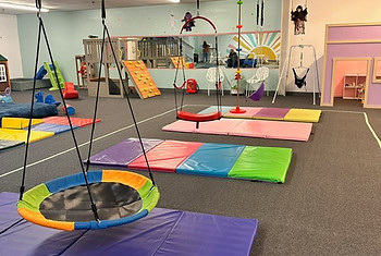 Indoor swings and padded motor-play area at The Playroom