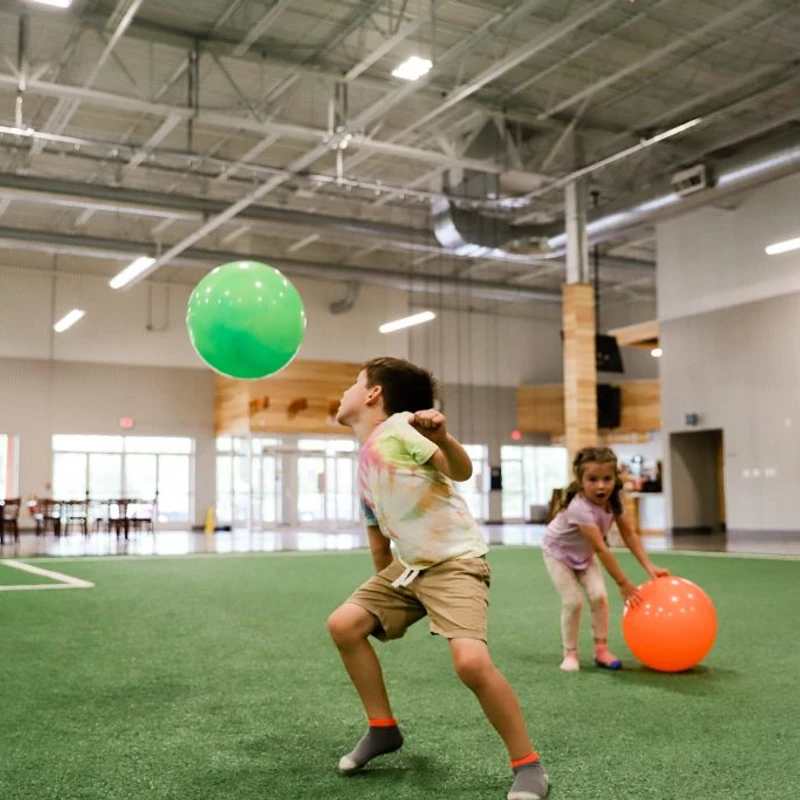 Children playing on indoor turf inside The Point community center.