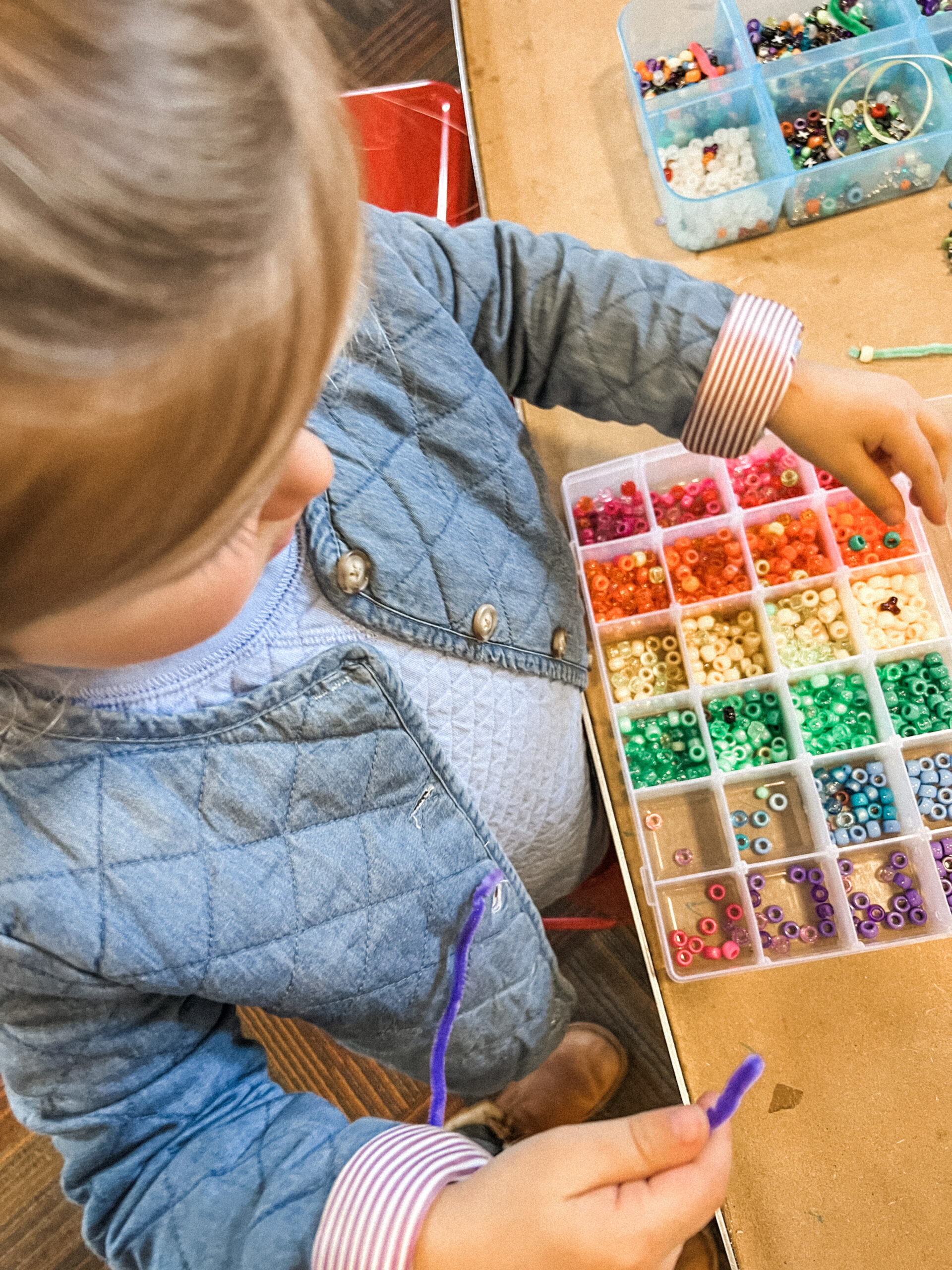 Child working at a table-based activity exhibit inside The Powerhouse.