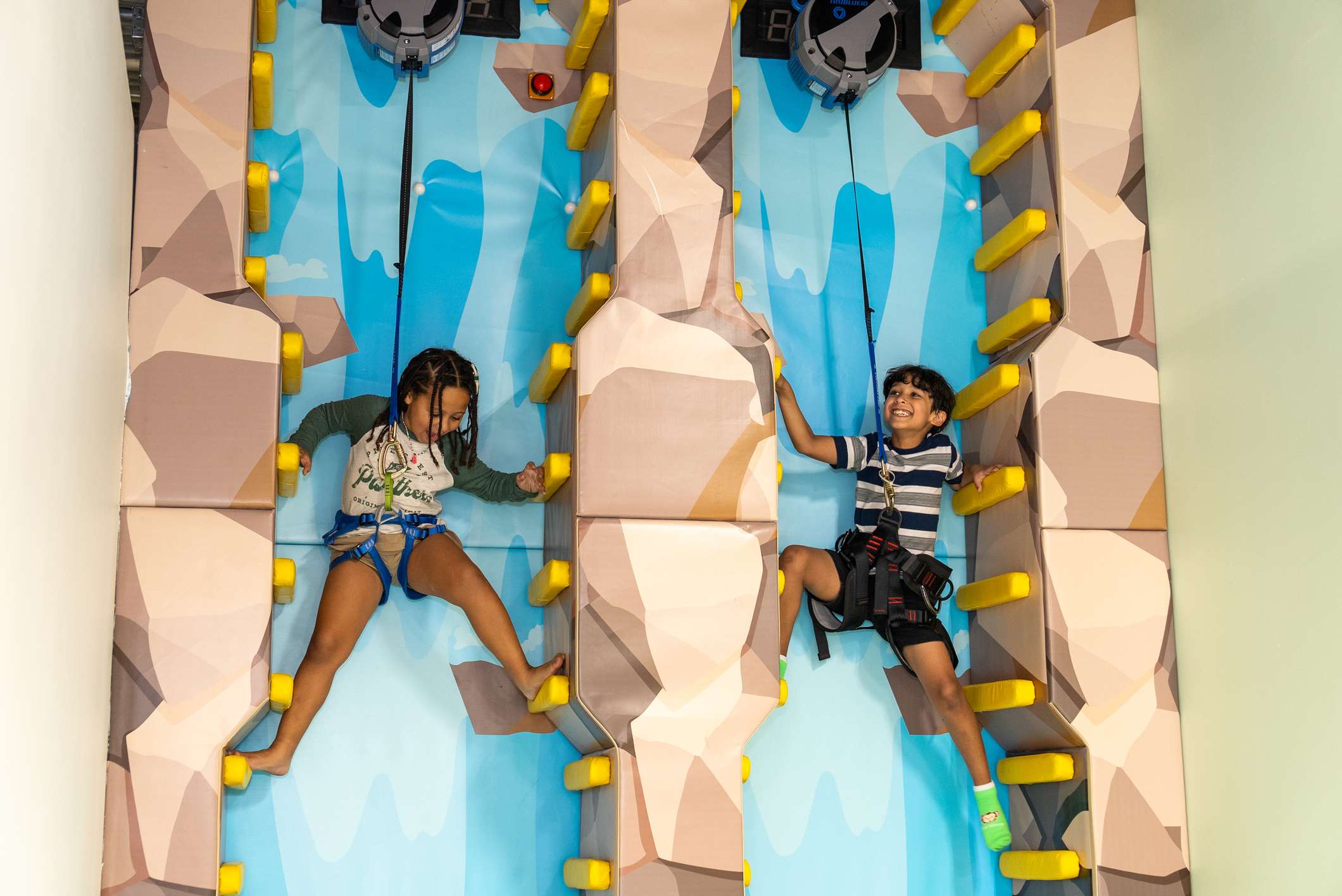 Children using the climbing wall and play structure at The Tree House Fort Lauderdale.