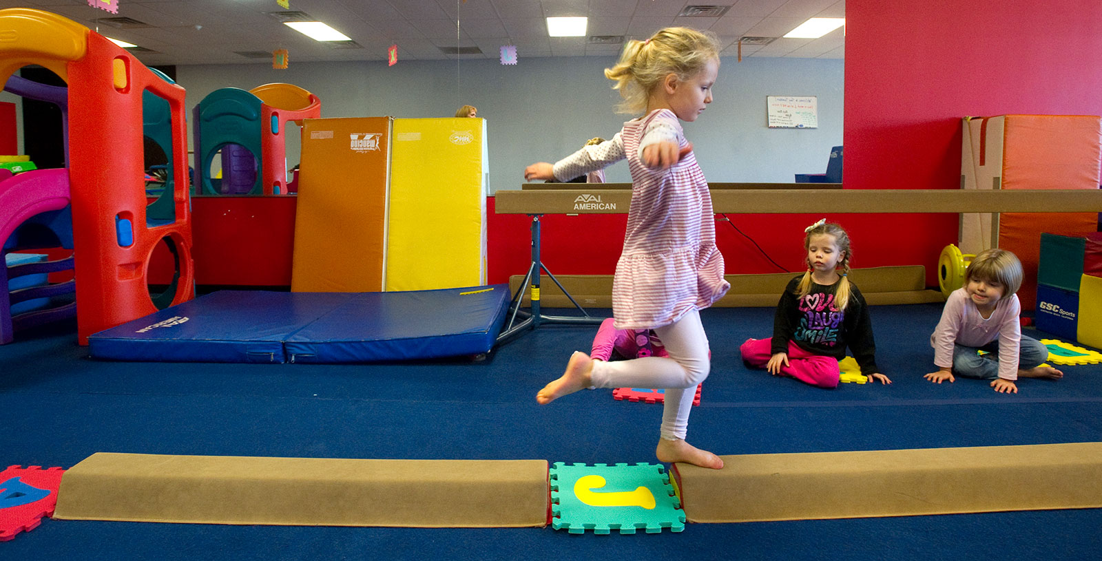 Children playing on soft gym equipment at Tiny Tumblers.
