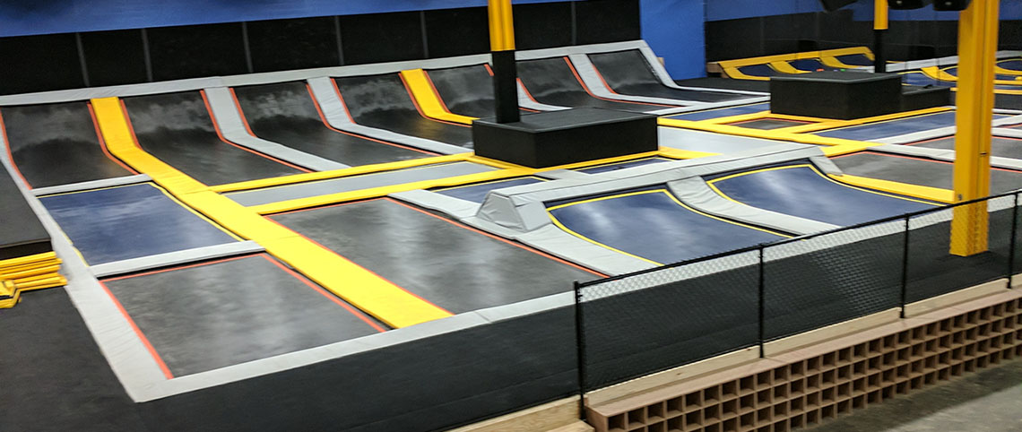 Wide view of trampoline lanes and angled wall trampolines at Ultimate Air Maui