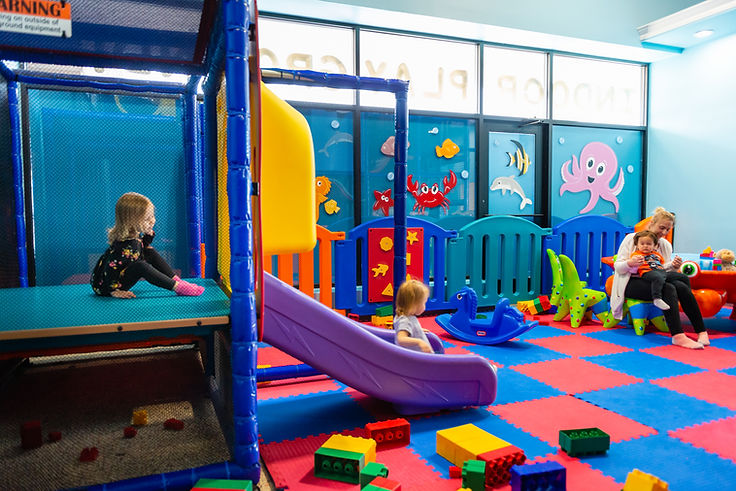 Colorful toddler play zone with small slide and seating area at Under The Sea Playground.