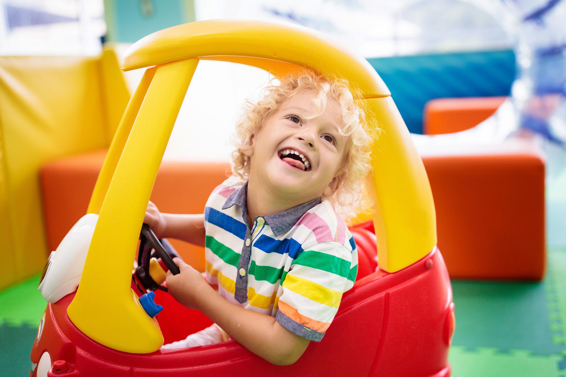 Children using ride-on toys during open play at Up & Away Indoor Play.