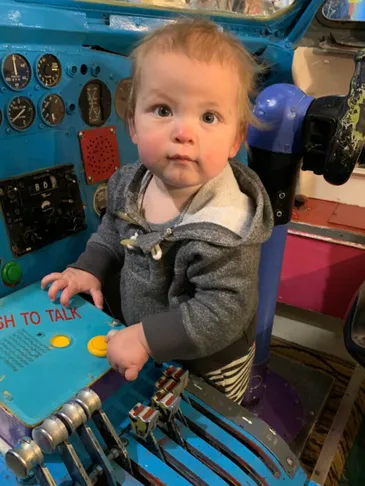 Toddler inside a real-jet cockpit-style hands-on exhibit.