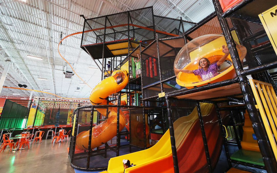 Indoor tubes-style playground with bright slides and nearby family seating at Urban Air Midland.