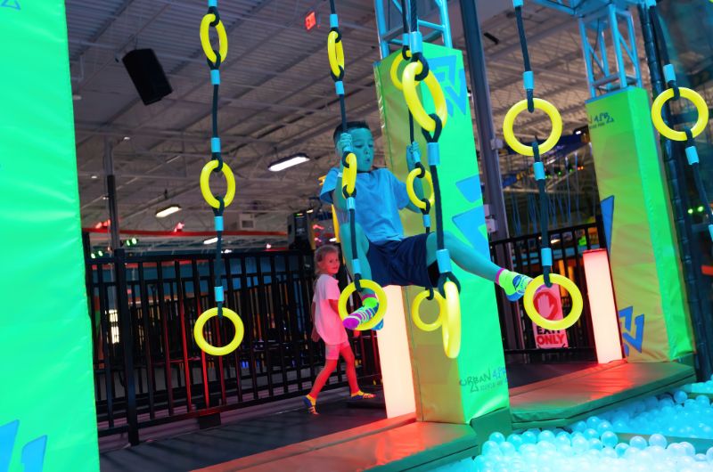 Kids crossing ring obstacles above a ball pit at Urban Air Adventure Park in South Jacksonville.