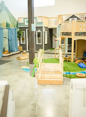 Open play floor at Valley Play Museum with playhouses and open walking paths.