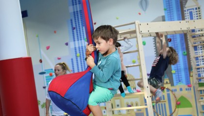 Child playing on suspended sensory equipment at We Rock the Spectrum Boca Raton East.