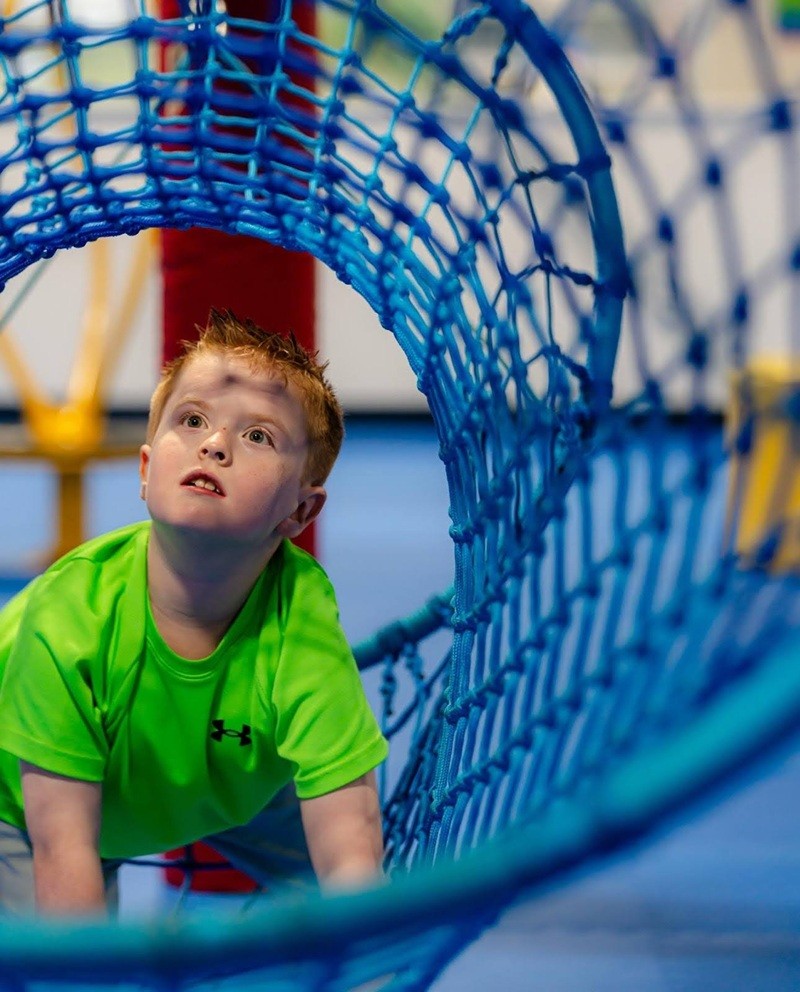 Child moving through netted equipment at We Rock the Spectrum - Cedar Rapids