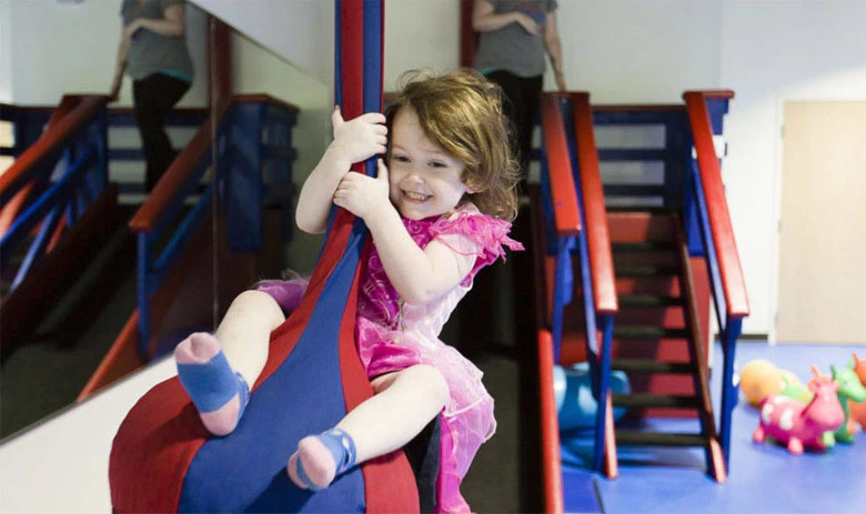 Child using the zip-slider style equipment at We Rock the Spectrum Clarksville
