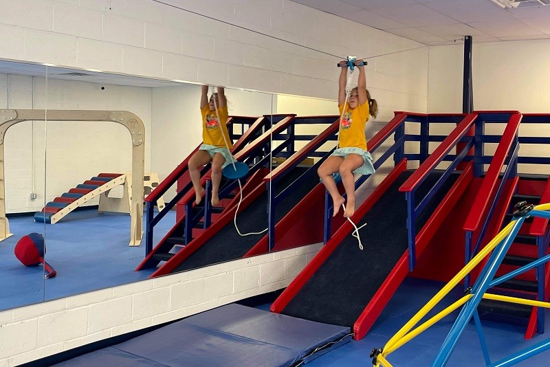Main open-play gym floor with colorful sensory equipment and active play stations.