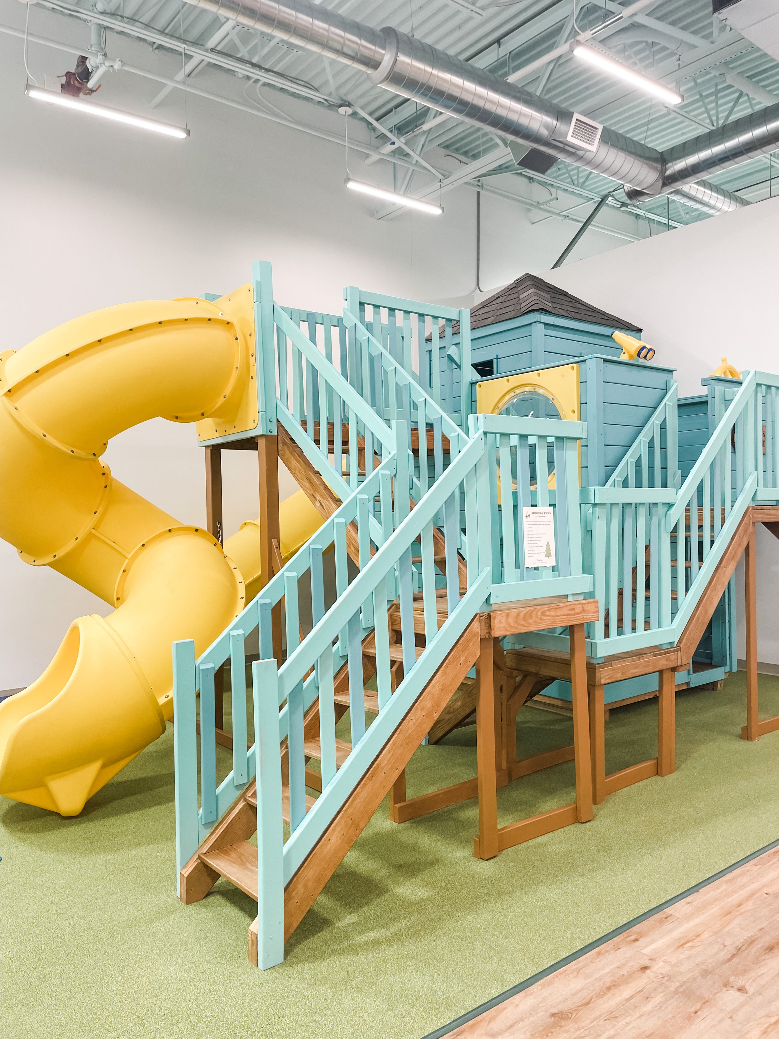 Large pastel-toned indoor play structure with slide and stairs at Where the Wild Things Play.