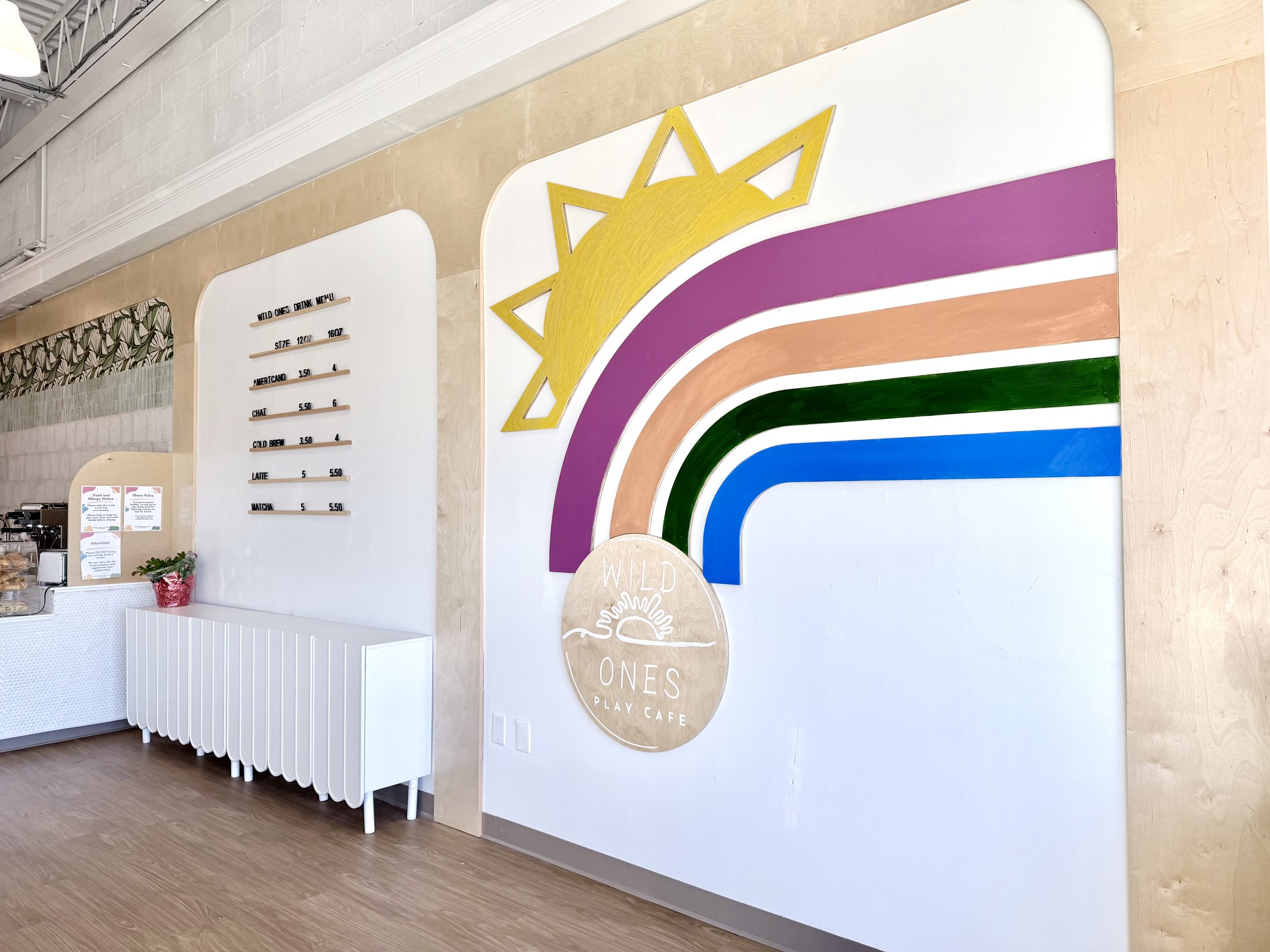 Rainbow mural and cafe counter area at Wild Ones Play Cafe.