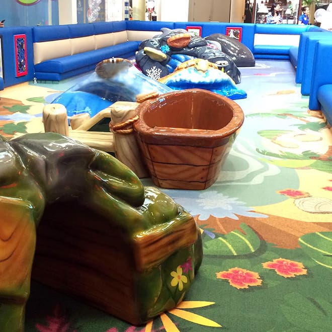 Boat and play sculptures inside the Windward Mall Play Area.