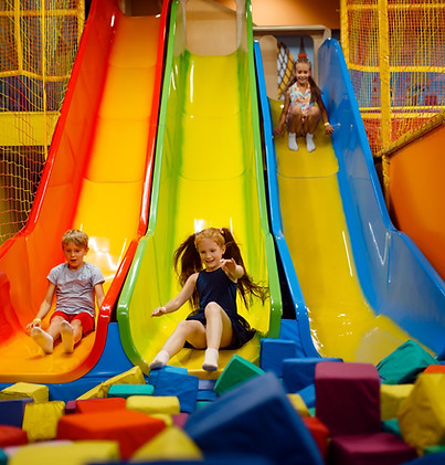 Kids sliding on brightly colored slides at Wonderworld Playzone.