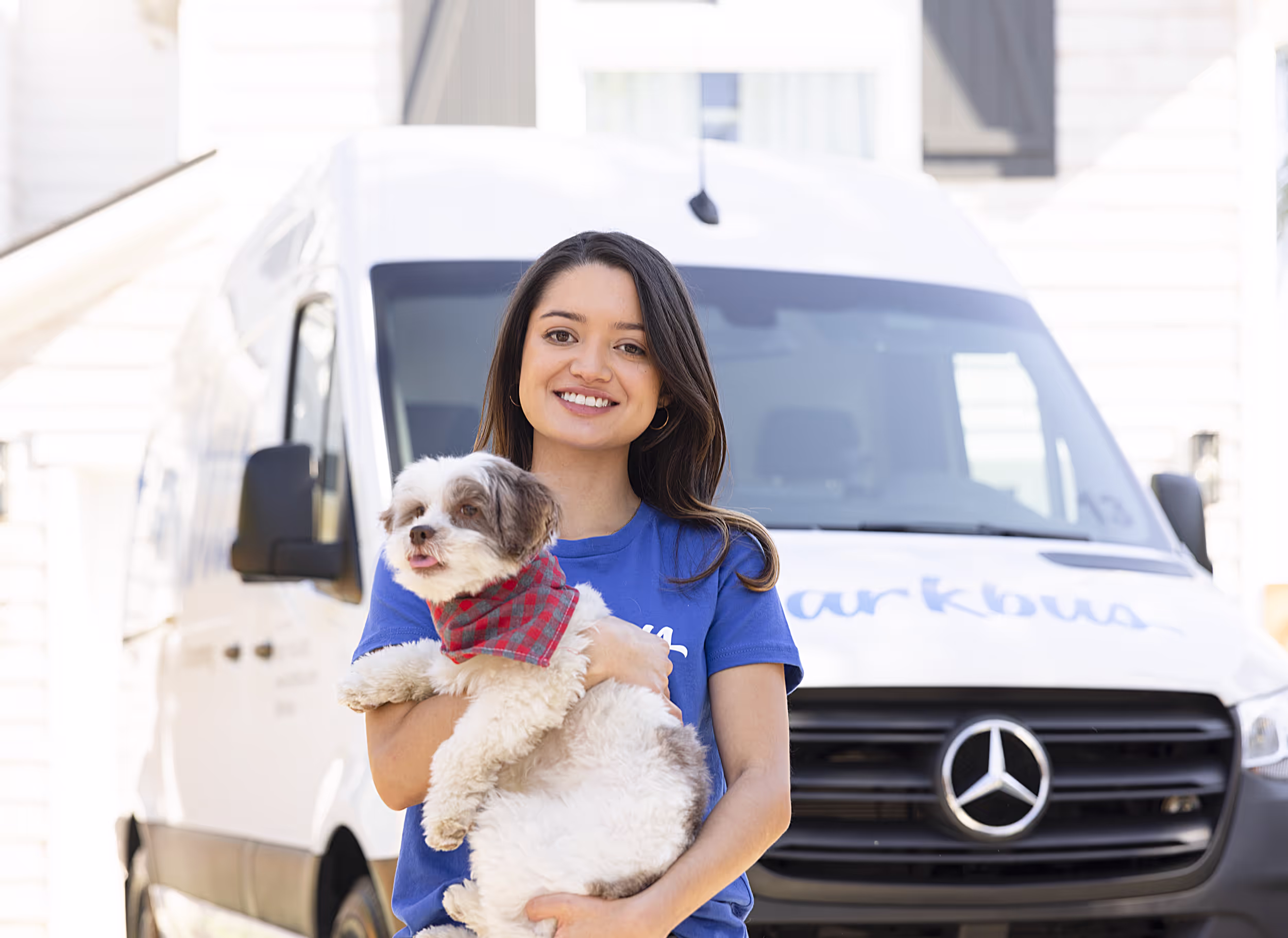 Barkbus groomer and dog in front of mobile grooming van